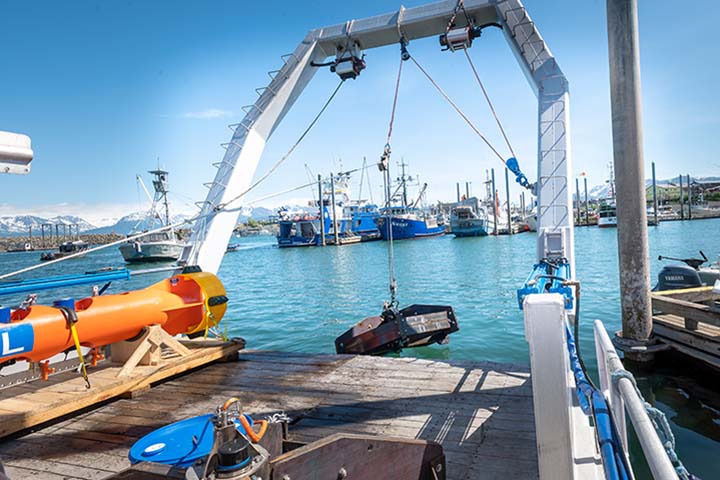 Two people stand on a boat surrounded by equipment